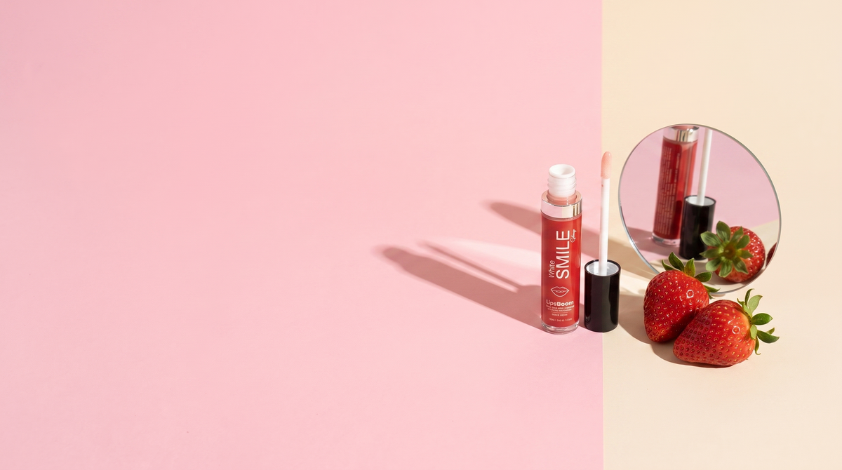 LipsBoom con fragole e specchio su fondo color-block rosa